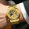 A close-up of a gold-toned men's stainless steel quartz wristwatch with an intricate, luminous dial on a person's wrist.