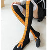A pair of black socks with an orange chicken print and white cuff, worn on a person's foot.