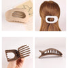 A set of flat circular hair clips in beige and brown tones shown with a hair strand.