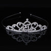 A sparkling crystal hair crown for women displayed on a reflective surface.