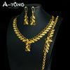 A luxury gold plated bridal jewelry set featuring earrings and a necklace displayed on a black mannequin.