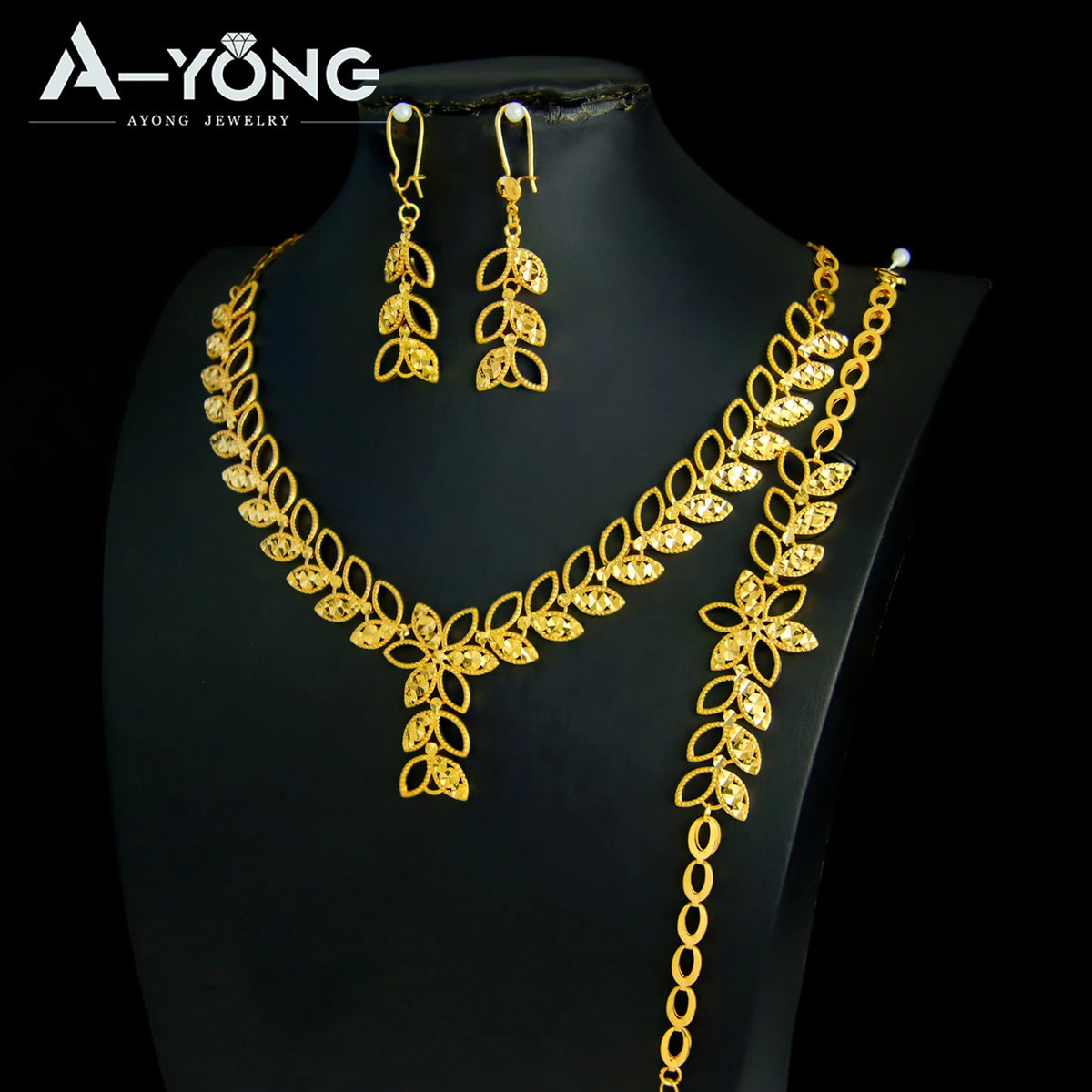 A luxury gold plated bridal jewelry set featuring earrings and a necklace displayed on a black mannequin.