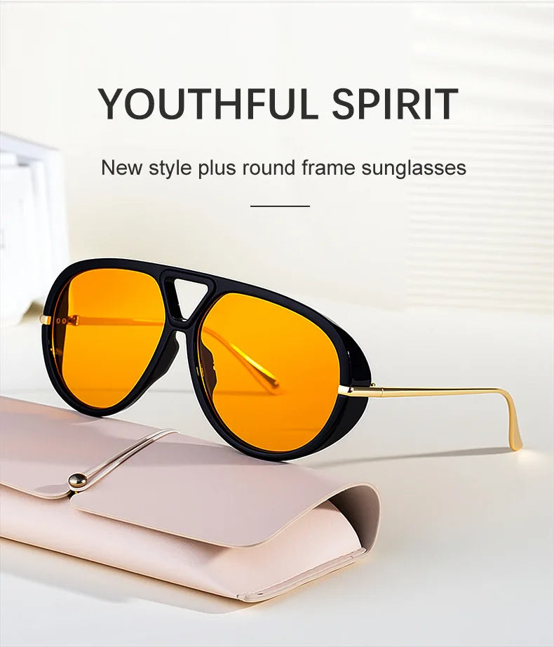Un par de gafas de sol redondas con marco naranja brillante, apoyadas en un estuche de cuero rosa claro.