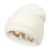 A cream-colored satin-lined beanie hat shown from the side.