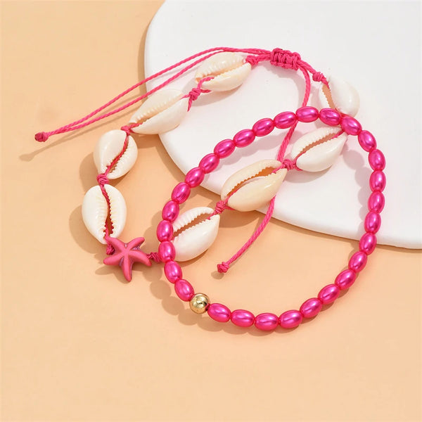 Pink beaded starfish conch anklet with white shell beads on a beige background