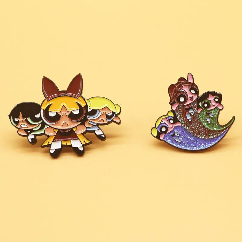 A pair of retro cartoon enamel lapel pins featuring stylized characters with dark hair and expressive faces.