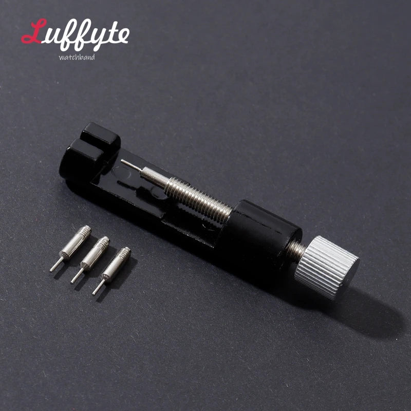 A black watchband repair tool kit with a needle and a threaded component is shown on a dark surface.