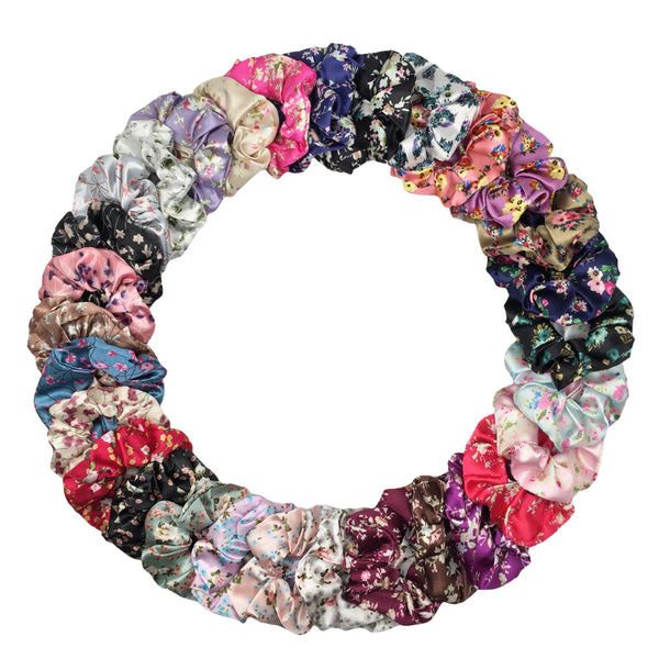 Disposición circular de seis gomas de tela con estampado floral de satén en varios colores pastel y oscuros.