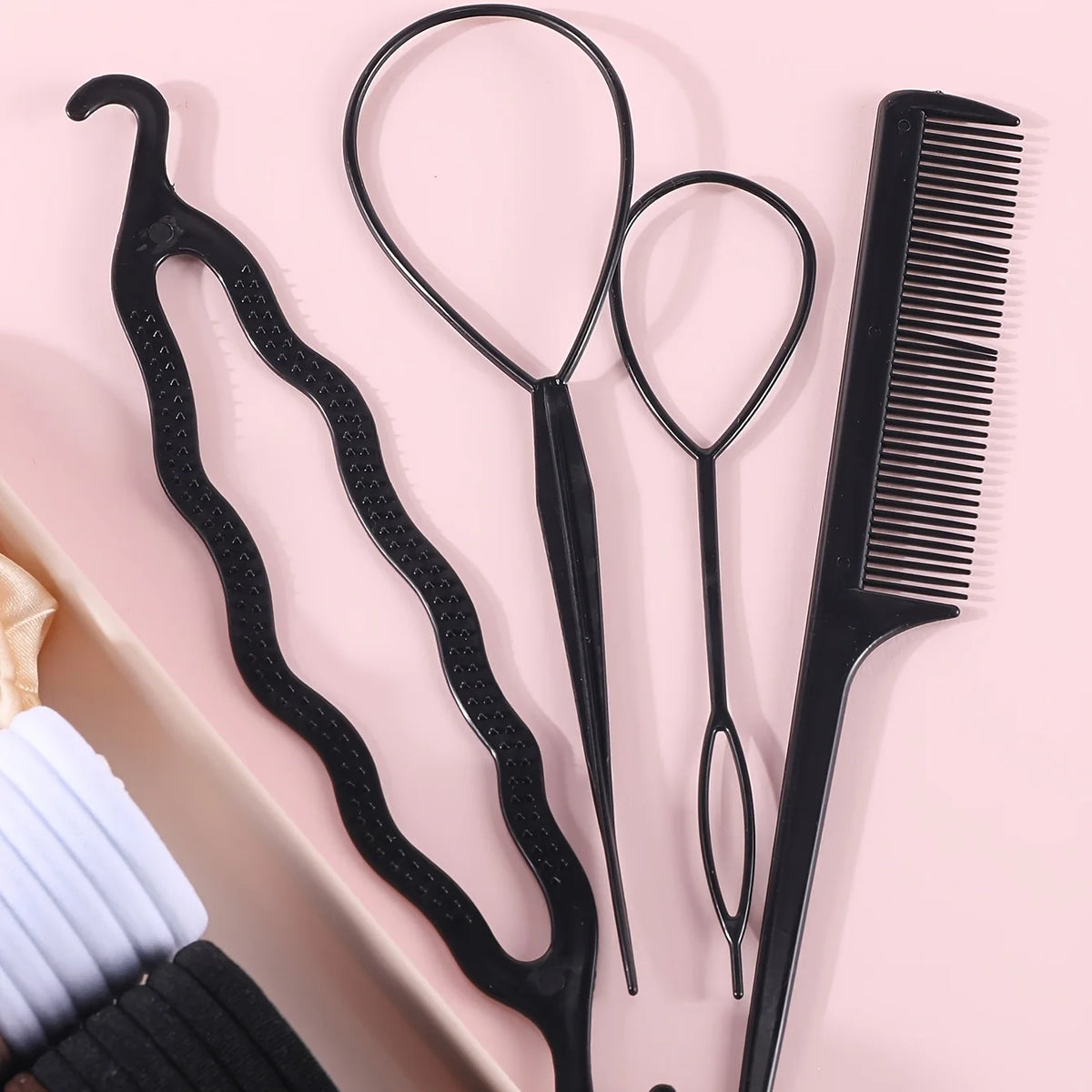 Un ensemble d'accessoires pour cheveux élastiques noirs, incluant un peigne et plusieurs reparateurs de cheveux, présentés su