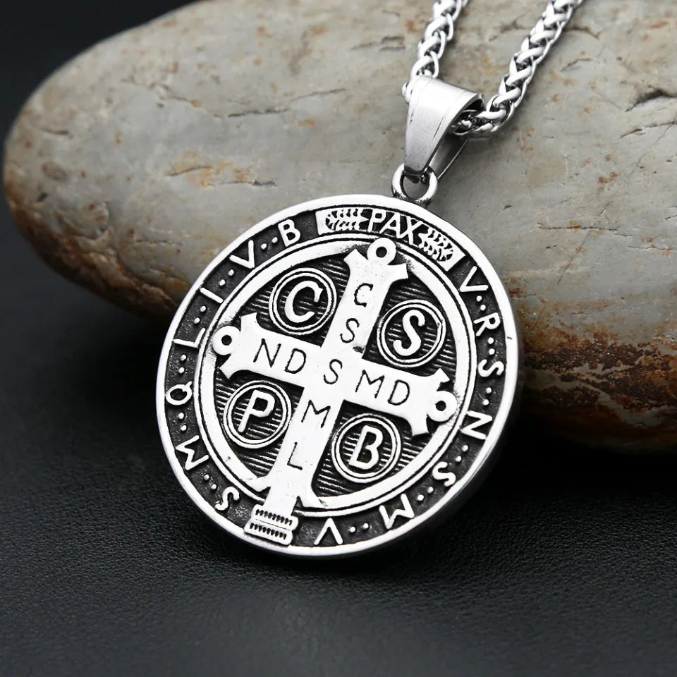 Silver pendant necklace featuring an intricate Saint Benedict exorcism design on a smooth stone background.