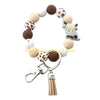 A keychain featuring a silicone charm shaped like a Highland cow, with various brown and white round charms.