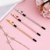 A set of stainless steel jewelry helper tools and a delicate chain are displayed on a pink background.