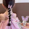 A woman's back shows a long black braided hairstyle adorned with pink butterfly hair ropes and pearl accents.