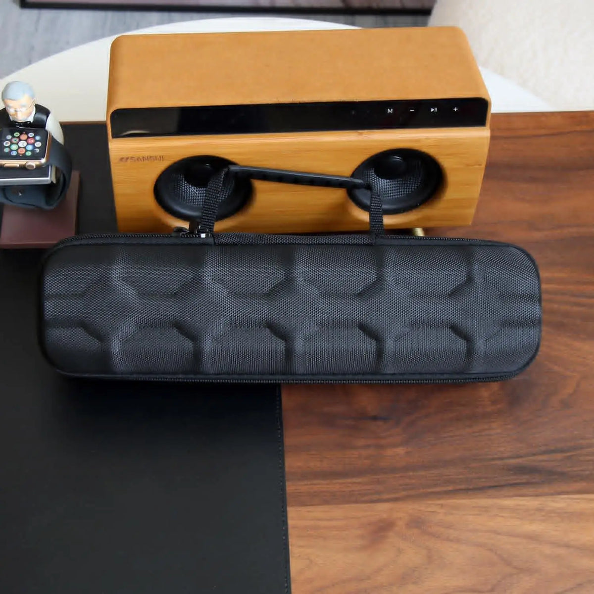 A wooden leather watch travel case organizer with black padded storage is displayed on a dark wood surface.