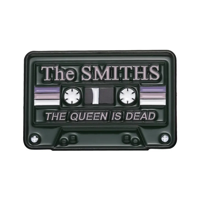 A black enamel pin brooch featuring the text The Smiths and The Queen Is Dead