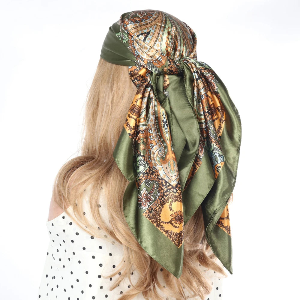 Blondes Haar eines Frau mit quadratischem Turban aus gemustertem olivgrünem Seidengewebe.