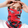 A woman wearing a red and gray camouflage face mask, adjusting it on her face.