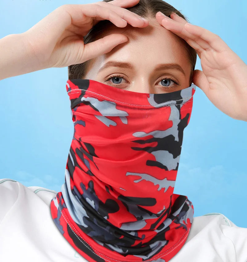 A woman wearing a red and gray camouflage face mask, adjusting it on her face.