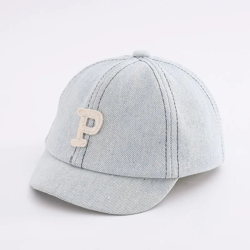 A light gray denim baseball cap with a tan embroidered letter P
