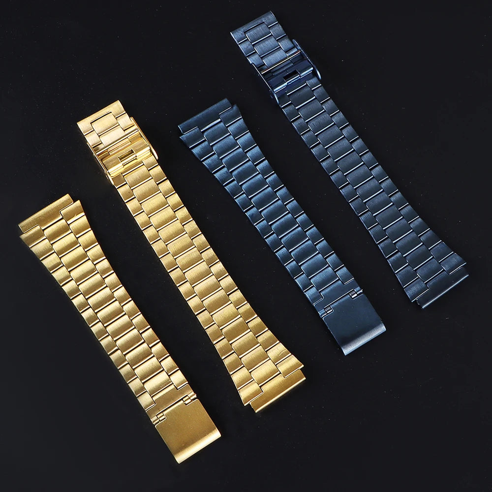 Drei Armbänder zur Uhr: goldfarben, dunkelblau und schwarz, diagonal auf dunklem Hintergrund.