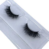 A pair of natural mink false eyelashes displayed in a clear plastic container.