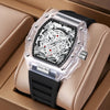 A clear silicone watch with a black face and silver accents is displayed in a light brown box.