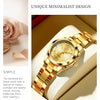 A close-up of a gold-toned luminous quartz watch with a leather strap resting on a cream-colored surface.
