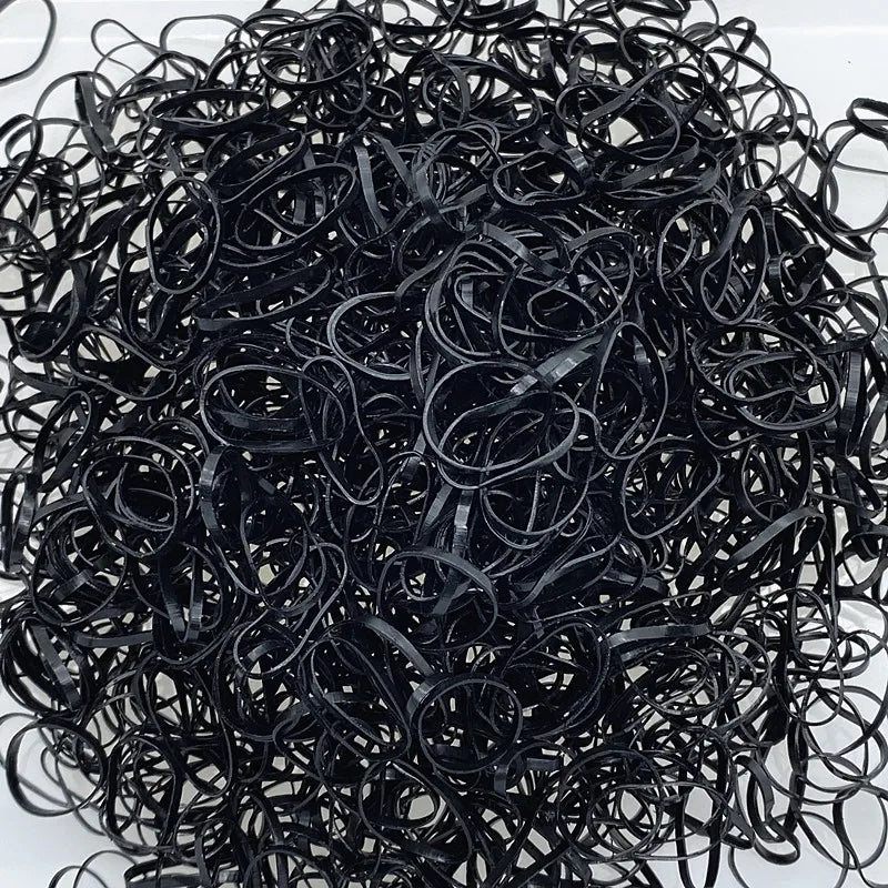 A pile of black disposable hair scrunchies for ponytail holders.
