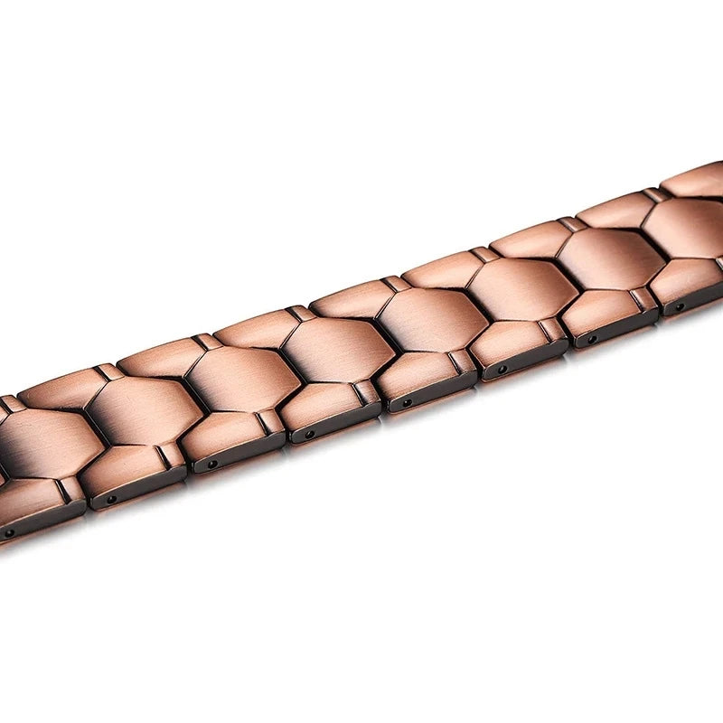 A close-up view of a copper magnetic therapy bracelet with a textured, hexagonal design.