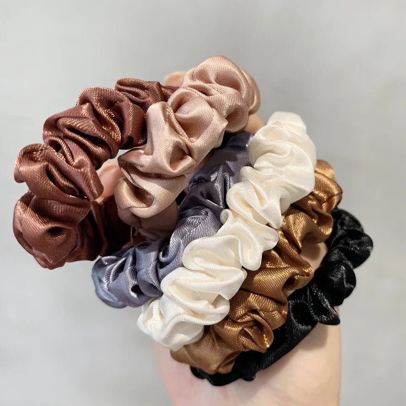 A collection of elegant simulation silk hair ties in various shades including brown, beige, gray, and black.