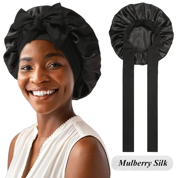 A woman models a black Mulberry Silk sleep bonnet with a white top, shown next to the product.