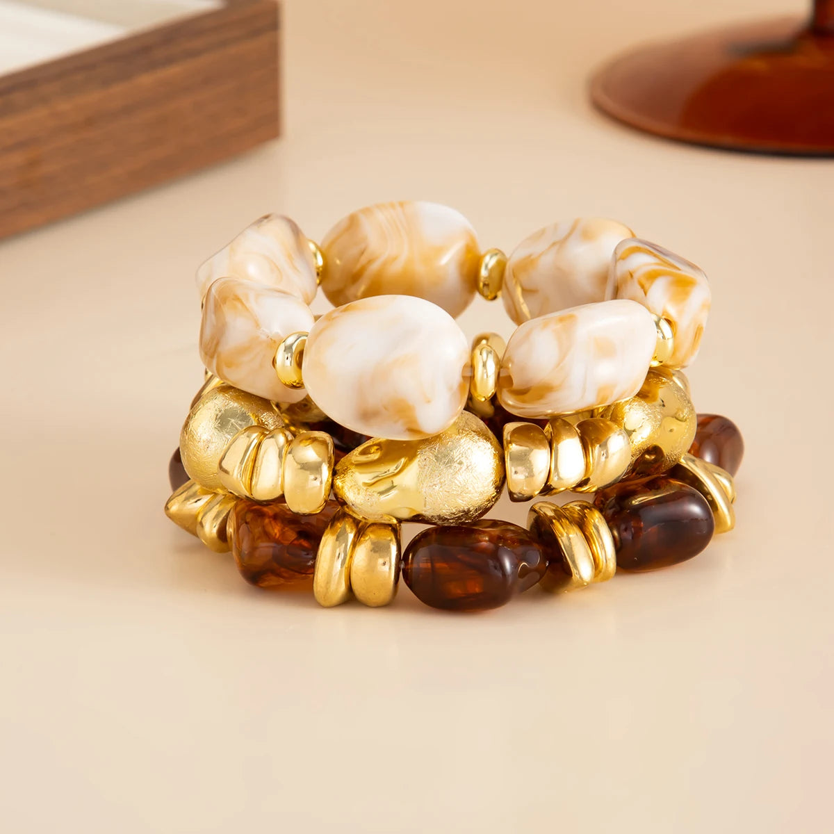Un set de bracelets vintage aux perles en résine marbrées claires et foncées, montés en métal doré.
