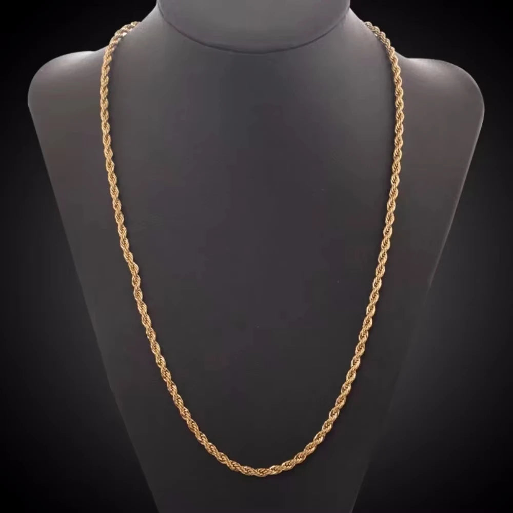 A close-up of a gold rope charm necklace displayed on a black display bust.