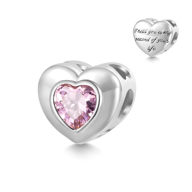 Colgante en forma de corazón plateado con una gema rosa y un pequeño dije de corazón