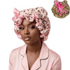 A woman wearing a pink leopard print hair drying cap and matching blouse.