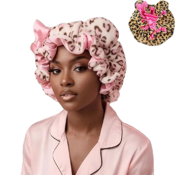 A woman wearing a pink leopard print hair drying cap and matching blouse.
