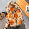 Gefaltener Luxus-Baumwoll-Pashmina-Schal in Orange- und Beige-Tönen auf einem Holztablett.