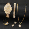 A set of gold-toned quartz watches, a gold chain necklace, and small gold rings displayed on a dark background.