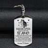 A silver stainless steel keychain tag with text in Spanish and English about love for a spouse