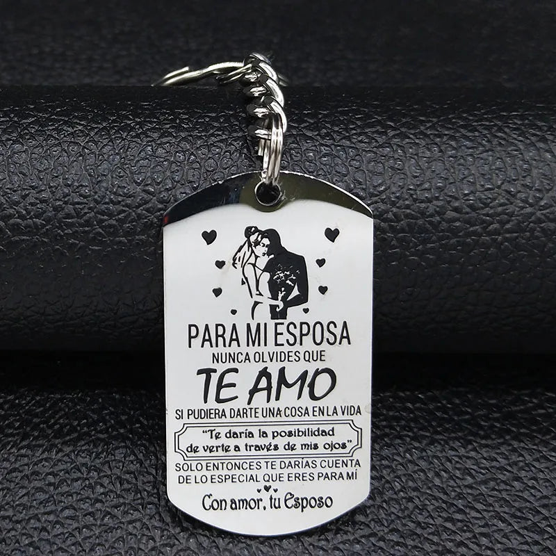 A silver stainless steel keychain tag with text in Spanish and English about love for a spouse