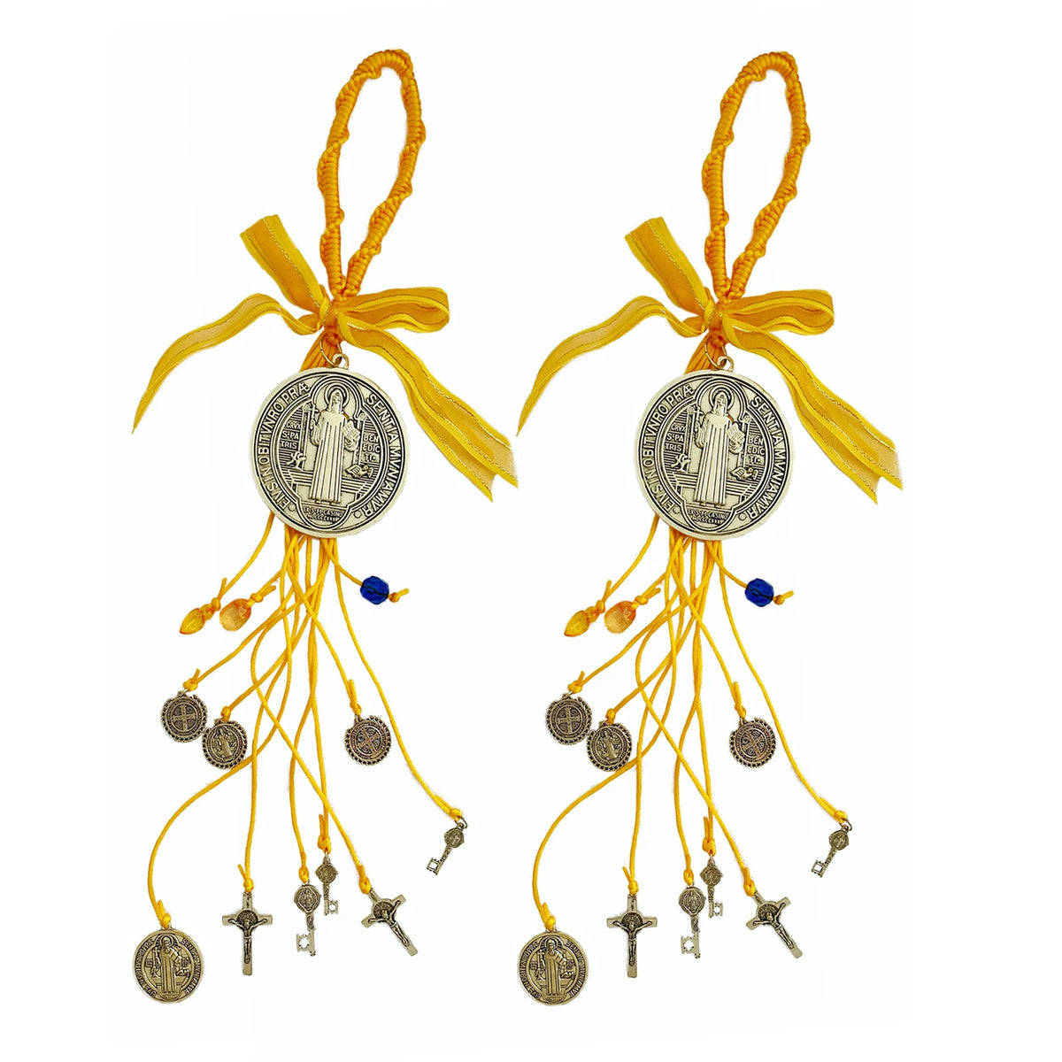 A set of golden Saint Benedict protection charms with yellow ribbons and dangling elements.