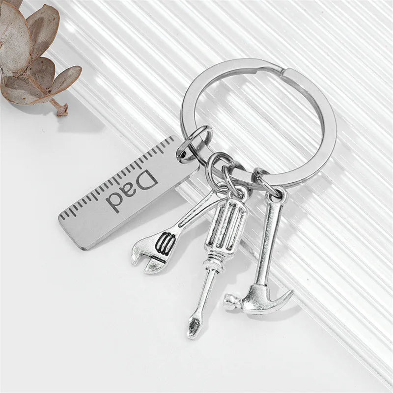 Silver multi-tool keychain set with pliers and knife attached to a measuring ruler
