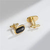 A pair of elegant gold-toned cufflinks featuring a black rectangular design with a subtle geometric pattern.