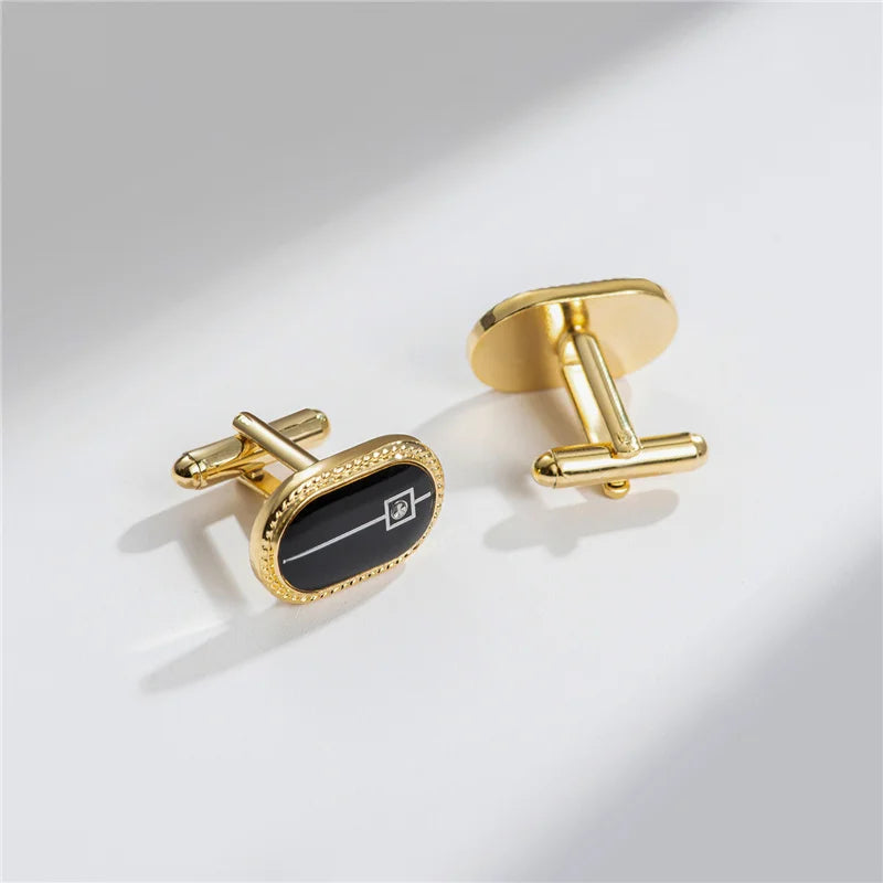 A pair of elegant gold-toned cufflinks featuring a black rectangular design with a subtle geometric pattern.