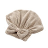 A beige microfiber hair drying towel tied in a bow.