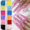 A collection of pink and white butterfly bow nail charms in various colors displayed on a hand.