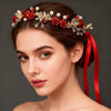 A close-up portrait of a woman wearing a red rose pearl crystal headband with a red ribbon.