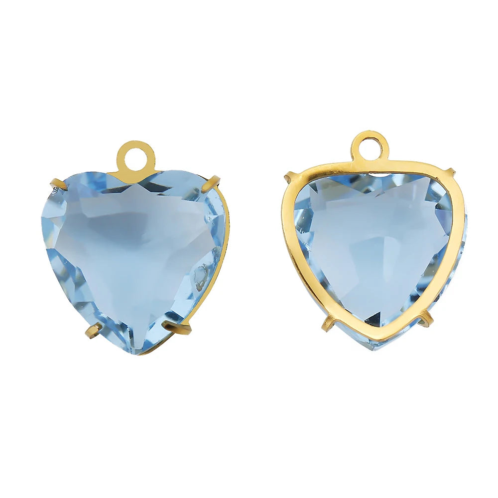 A pair of heart-shaped crystal pendants with a light blue color set in gold-toned stainless steel.