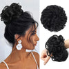 A close-up of a woman's dark hair styled in an elegant updo with white floral accessories.