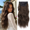 A close-up of long, wavy brown hair with dark ombre tips, featuring black clips for styling.